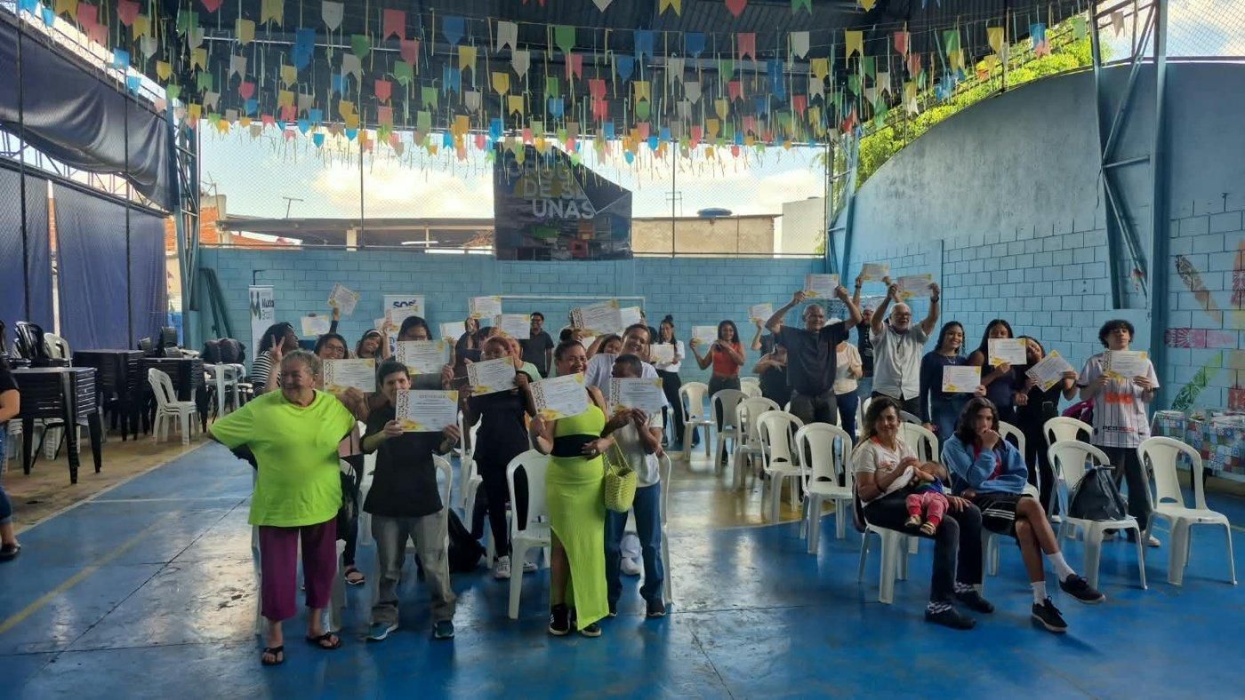 Turma comemorando com os certificados em espaço comunitário